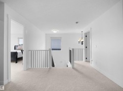 The landing features soft carpet flooring, white walls, and a window with blinds - 