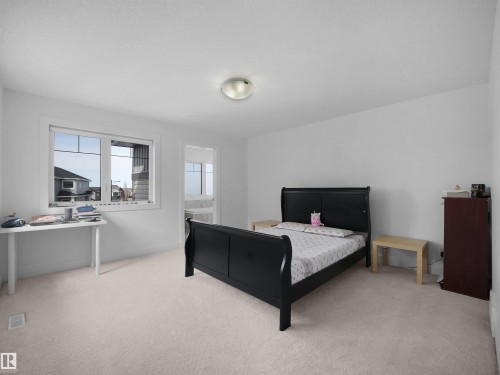 This room features a window providing natural light, light-colored carpeting, and a ceiling-mounted light fixture - 4231 Charles Close, Edmonton, AB - Indoor Photo Showing Bedroom