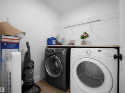 Laundry area featuring a side-by-side washer and dryer, a countertop surface, and wire shelving - 
