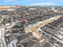 Aerial view of the neighborhood showcasing residential properties with grey roofs and varied exterior finishes, alongside a paved street and surrounding open land - 4231 Charles Close, Edmonton, AB  - Outdoor With View 