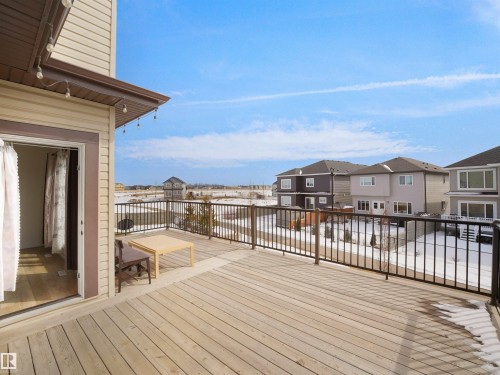 The property features a spacious outdoor deck with light-colored wooden planks and dark metal railings - 4231 Charles Close, Edmonton, AB - Outdoor With Deck Patio Veranda With Exterior