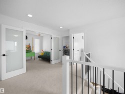 Bright open area with light-colored carpeting, white walls, and recessed lighting - 