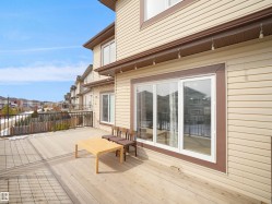 The property features a spacious deck with a wooden surface and a dark-colored railing - 