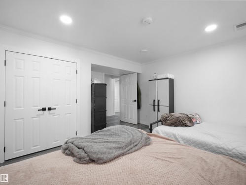 This room features white walls, recessed ceiling lighting, crown molding, and light-toned flooring - 4231 Charles Close, Edmonton, AB - Indoor Photo Showing Bedroom