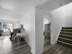 This property features an open-concept living area with light-colored flooring and a large window, providing natural illumination - 