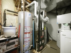 Utility area featuring a water heater, furnace, and washer and dryer units - 