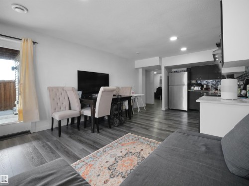 Open concept living area featuring wood plank flooring, a dining area, and a kitchen with stainless steel appliances - 4231 Charles Close, Edmonton, AB - Indoor