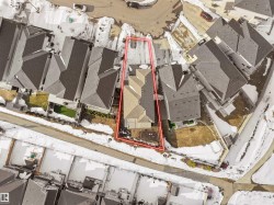 Aerial view of the property, showcasing its location within a residential area with other homes and streets - 