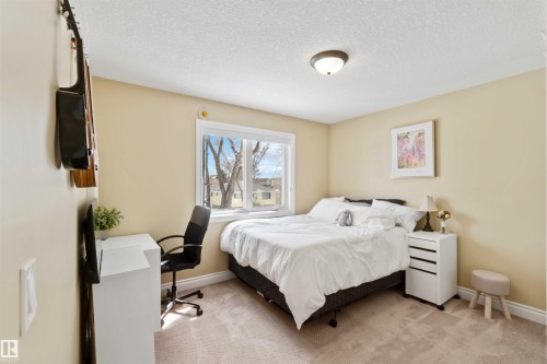 Bedroom featuring a large window, neutral wall paint, and light-toned carpeting - 10630 82 Street, Edmonton, AB - Indoor Photo Showing Bedroom