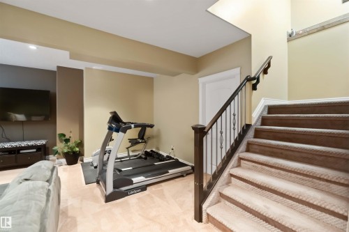 Carpeted staircase with dark wood newel posts and metal balusters - 10630 82 Street, Edmonton, AB - Indoor Photo Showing Other Room