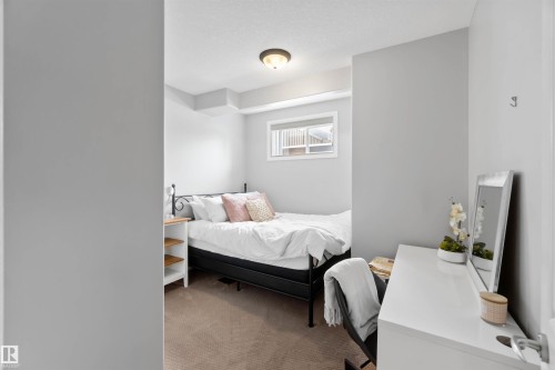 Carpeted room featuring light gray walls, a window with exterior visibility, and a ceiling-mounted light fixture - 10630 82 Street, Edmonton, AB - Indoor Photo Showing Bedroom