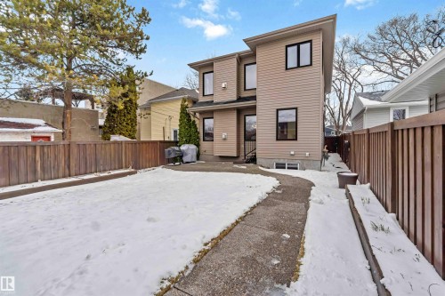 Contemporary property exterior featuring light beige siding and dark-trimmed windows - 10630 82 Street, Edmonton, AB - Outdoor