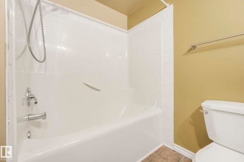 Full bath featuring bathtub / shower combination and tile patterned floors - 310 10606 102 Avenue, Edmonton, AB - Indoor Photo Showing Bathroom