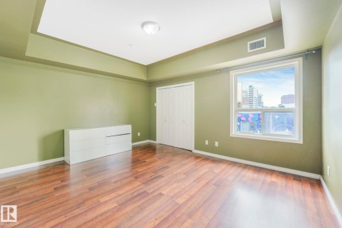 Unfurnished bedroom featuring wood finished floors, a raised ceiling, and a closet - 310 10606 102 Avenue, Edmonton, AB - Indoor Photo Showing Other Room