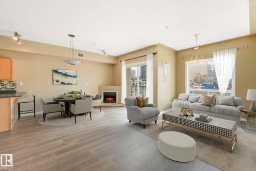 Living room featuring a lit fireplace and light wood finished floors - 310 10606 102 Avenue, Edmonton, AB - Indoor Photo Showing Living Room With Fireplace