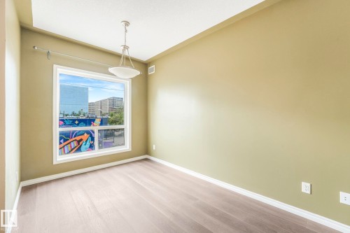 Unfurnished room featuring wood finished floors and baseboards - 310 10606 102 Avenue, Edmonton, AB - Indoor Photo Showing Other Room