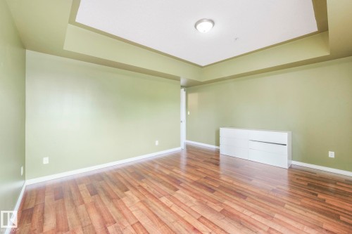 Empty room featuring a tray ceiling and wood finished floors - 310 10606 102 Avenue, Edmonton, AB - Indoor Photo Showing Other Room