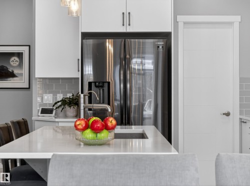 Kitchen island featuring a built-in sink and light-toned countertop - 323 Balsam Link, Leduc, AB - Indoor