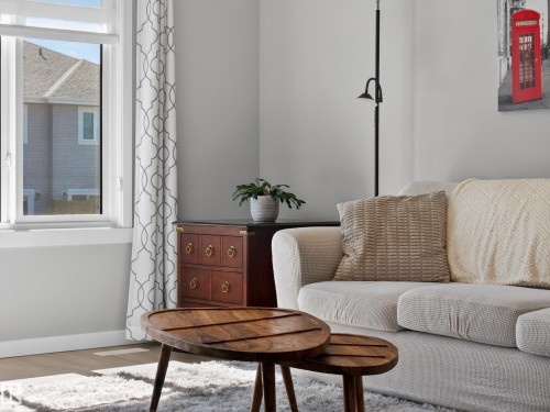 Spacious room featuring white wall paint, light wood-finish flooring, and natural light from a large window - 323 Balsam Link, Leduc, AB - Indoor
