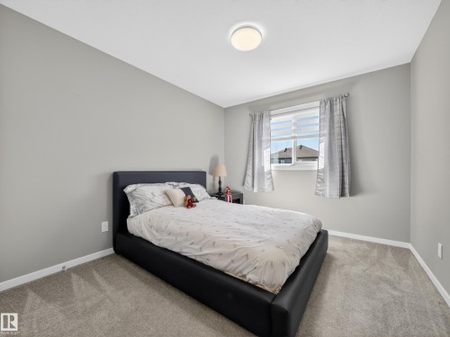 Room featuring gray wall paint, light-colored carpet flooring, a window with blinds, and a flush mount ceiling light fixture - 323 Balsam Link, Leduc, AB - Indoor Photo Showing Bedroom