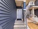Entryway featuring a light gray door with decorative glass, concrete steps, and a metal handrail - 323 Balsam Link, Leduc, AB  - Outdoor With Deck Patio Veranda 