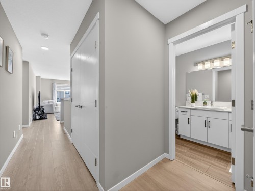 Hallway entrance featuring wood-finish flooring, light grey walls, and white trim - 323 Balsam Link, Leduc, AB - Indoor Photo Showing Other Room