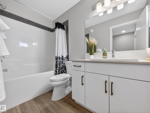 Bathroom featuring a white vanity with dark bronze hardware, a rectangular undermount sink, and a light-toned countertop - 323 Balsam Link, Leduc, AB - Indoor Photo Showing Bathroom