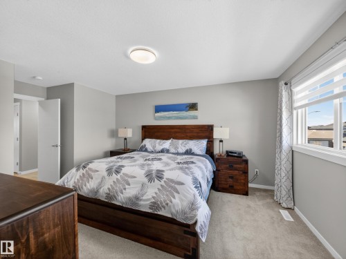 Carpeted bedroom featuring neutral grey walls and a ceiling-mounted light fixture - 323 Balsam Link, Leduc, AB - Indoor Photo Showing Bedroom