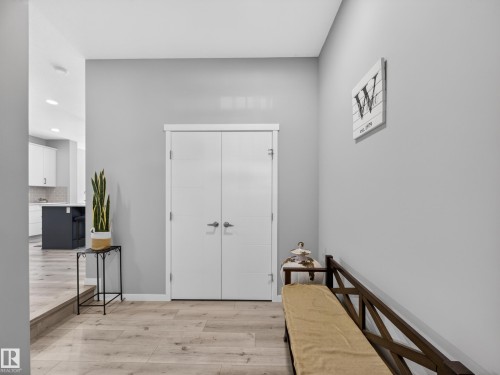 Entryway featuring light wood-finish flooring, light gray walls, and white bi-fold doors - 323 Balsam Link, Leduc, AB - Indoor Photo Showing Other Room