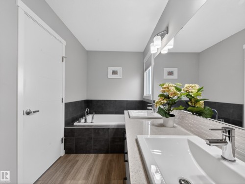 Bathroom featuring a dual vanity with undermount sinks, chrome fixtures, and a large mirror - 323 Balsam Link, Leduc, AB - Indoor Photo Showing Bathroom