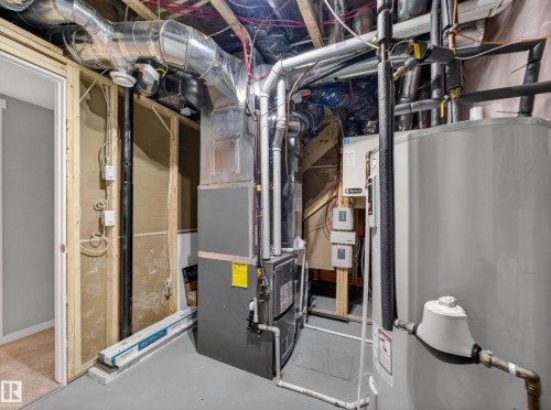 Utility room featuring a furnace, water heater, and exposed overhead ductwork - 323 Balsam Link, Leduc, AB - Indoor Photo Showing Basement