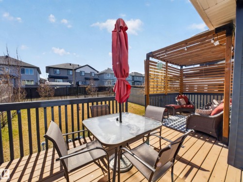 Expansive wooden deck featuring a slatted privacy screen, overhead pergola, and dark gray railing - 323 Balsam Link, Leduc, AB - Outdoor With Deck Patio Veranda With Exterior