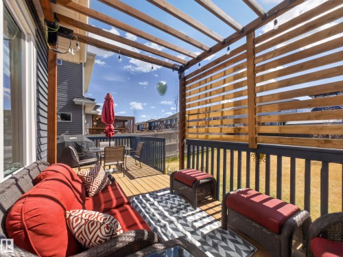 Expansive outdoor deck featuring wood-finish flooring, a slatted privacy screen, and an open pergola structure - 323 Balsam Link, Leduc, AB - Outdoor With Deck Patio Veranda