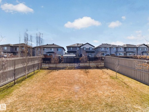 Spacious backyard featuring a large grass area, mature deciduous trees, and privacy fencing - 323 Balsam Link, Leduc, AB - Outdoor