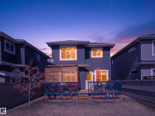 Rear exterior with a wood deck, horizontal privacy screen, and a fenced backyard - 323 Balsam Link, Leduc, AB - Outdoor