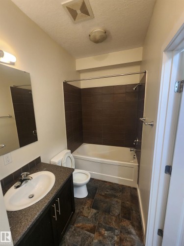 Bathroom with washtub / shower combination, vanity, and a textured ceiling - 12246 103 Street Nw, Edmonton, AB - Indoor Photo Showing Bathroom
