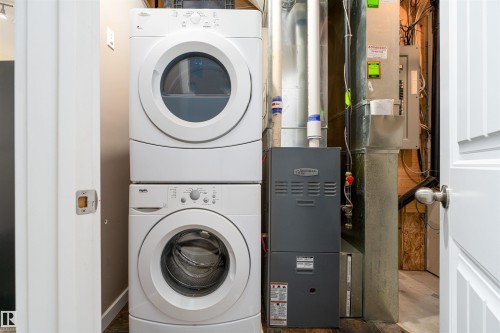 Laundry room featuring heating unit and stacked washer / drying machine - 12246 103 Street Nw, Edmonton, AB - Indoor Photo Showing Laundry Room