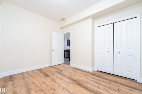 Unfurnished bedroom featuring light wood-type flooring and a closet - 12246 103 Street Nw, Edmonton, AB - Indoor Photo Showing Other Room