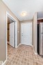 Entryway featuring diamond-patterned tile flooring, a white paneled door, and a flush-mount ceiling light - 344 1520 Hammond Gate Gate, Edmonton, AB  - Indoor 