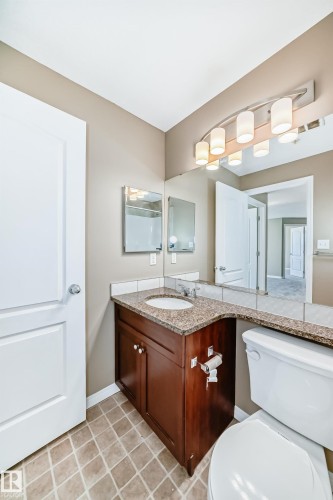 Bathroom featuring a dark wood vanity with a granite countertop, undermount sink, and tiled flooring - 344 1520 Hammond Gate Gate, Edmonton, AB - Indoor Photo Showing Bathroom