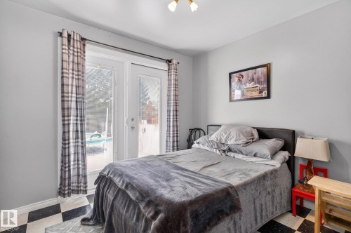 French doors with exterior access and plaid drapery - 9112 130 Avenue, Edmonton, AB - Indoor Photo Showing Bedroom