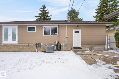 Rear exterior featuring tan horizontal siding and a brown shingle roof - 9112 130 Avenue, Edmonton, AB - Outdoor