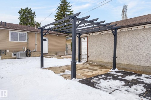 Outdoor pergola structure with string lighting, concrete patio, and visible exterior wall with stucco finish - 9112 130 Avenue, Edmonton, AB - Outdoor