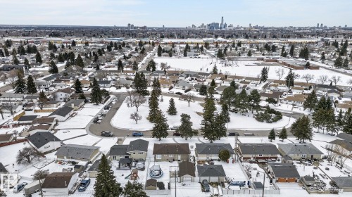 Mature residential neighborhood featuring established trees and a distant cityscape skyline - 9112 130 Avenue, Edmonton, AB - Outdoor With View