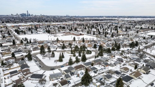 Aerial perspective showcasing a residential neighborhood with a distant cityscape - 9112 130 Avenue, Edmonton, AB - Outdoor With View