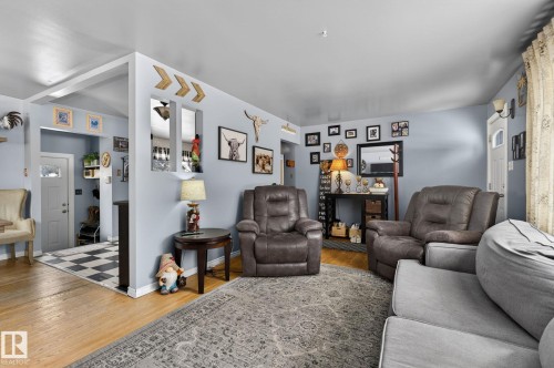 Living area featuring light wood-finish flooring and light blue wall paint - 9112 130 Avenue, Edmonton, AB - Indoor Photo Showing Living Room