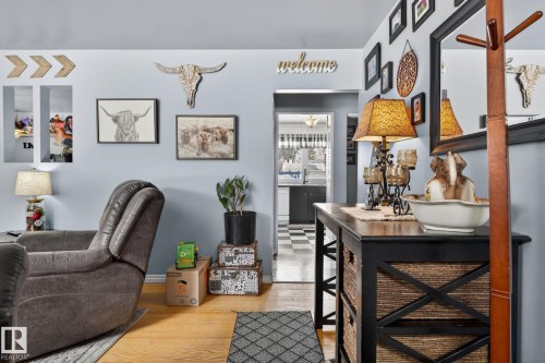 Hardwood-finish flooring extending into the hallway and a passageway to a kitchen with checkerboard flooring - 9112 130 Avenue, Edmonton, AB - Indoor Photo Showing Other Room
