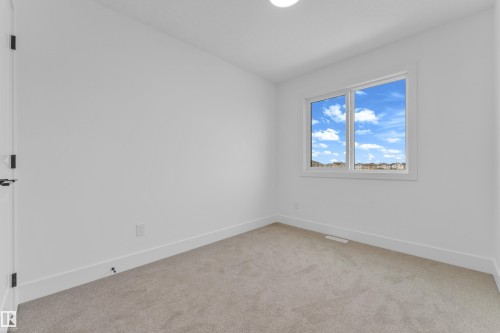 Bright interior space featuring a double-paned window, neutral carpet flooring, white walls, and white trim - 277 Munn Way, Leduc, AB - Indoor Photo Showing Other Room