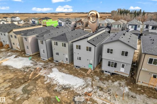 Recently constructed homes with light gray siding and dark shingle roofs - 277 Munn Way, Leduc, AB - Outdoor