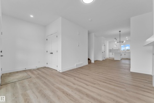 Open-concept living space featuring wood-finish flooring, recessed lighting, and white walls - 277 Munn Way, Leduc, AB - Indoor Photo Showing Other Room